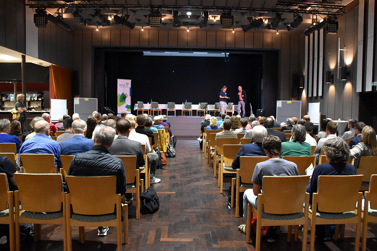 Sicht auf eine große Bühne. Das Publikum ist von hinten zu sehen. (Quelle: Ellen Boettcher) Sicht auf eine große Bühne. Das Publikum ist von hinten zu sehen.